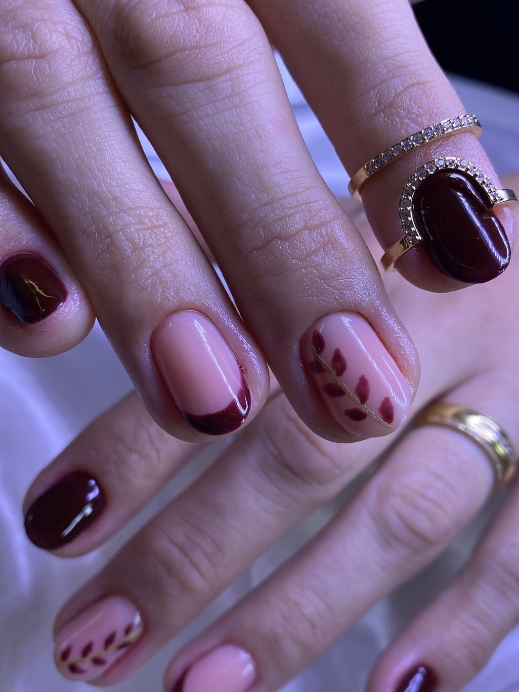 Unhas curtas com francesinha vinho e ramo dourado