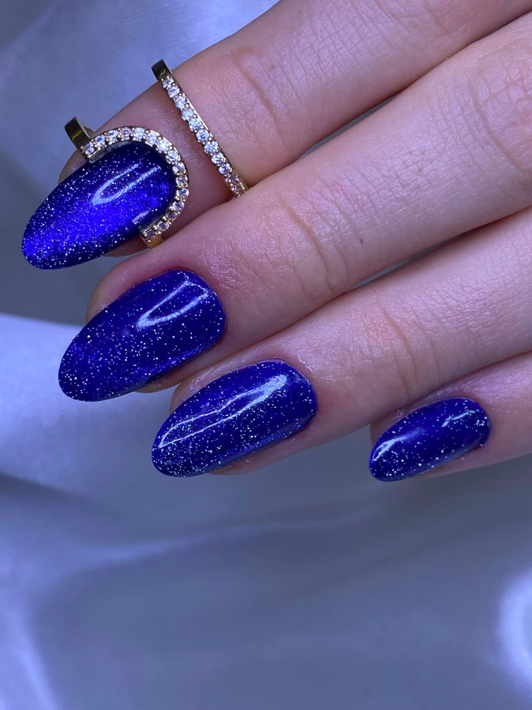 Unhas azul royal com efeito cat eye e glitter