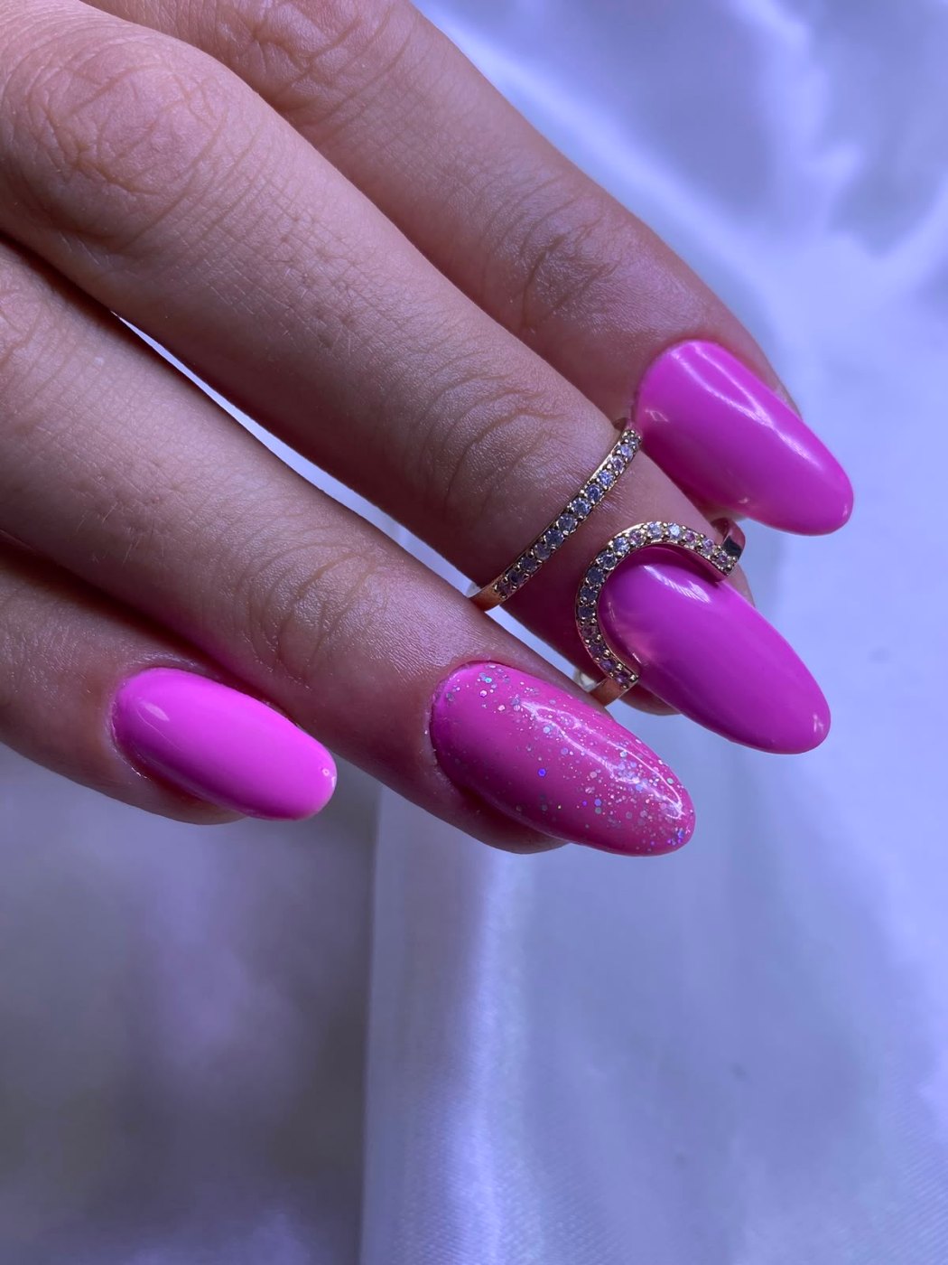 Unhas pink em formato amendoado, com uma unha em glitter